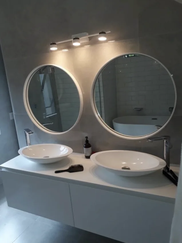 Completed bathroom fit-out with double vanity and round mirrors